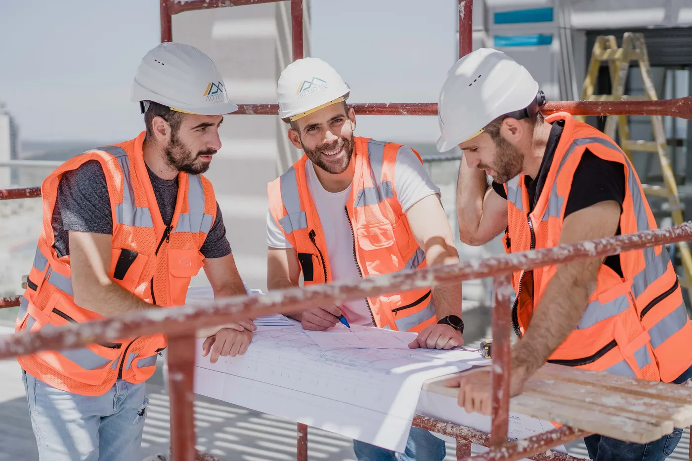 מהנדסי עוז הנדסה בוחנים תוכניות על פיגום באתר בנייה