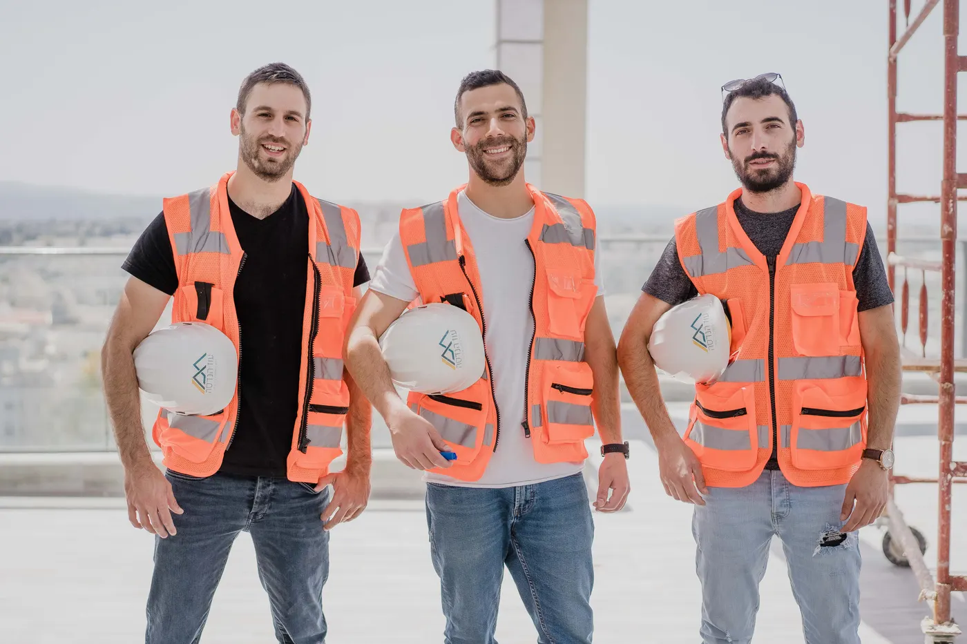 צוות עוז הנדסה על גג אתר בנייה, בקסדות ואפודי בטיחות